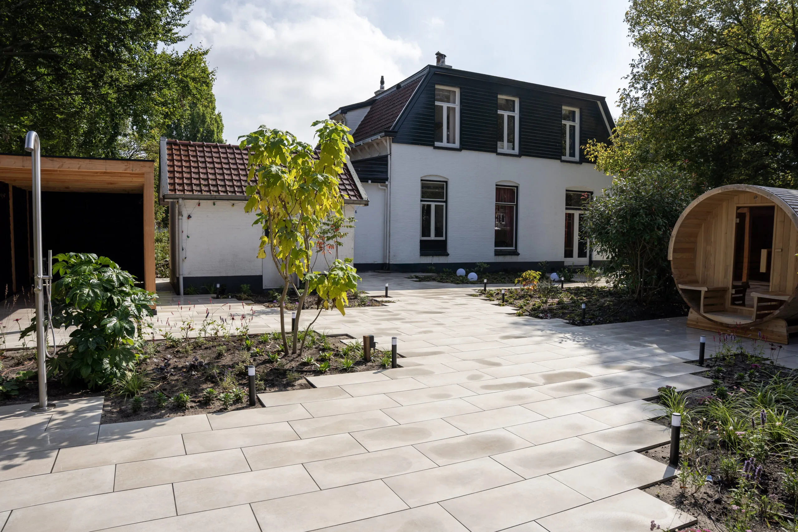 Moderne wellness-tuin met strakke bestrating in de avondsfeer