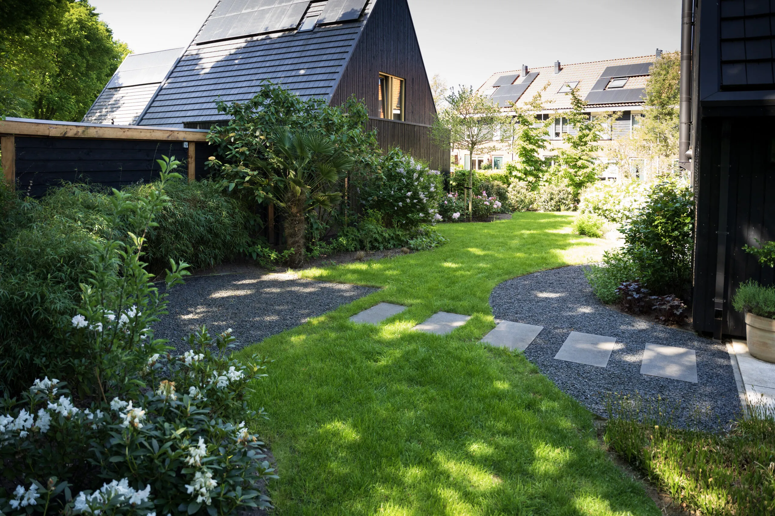 Natuurlijke groene tuin met gazon en volle borders aan de bosrand