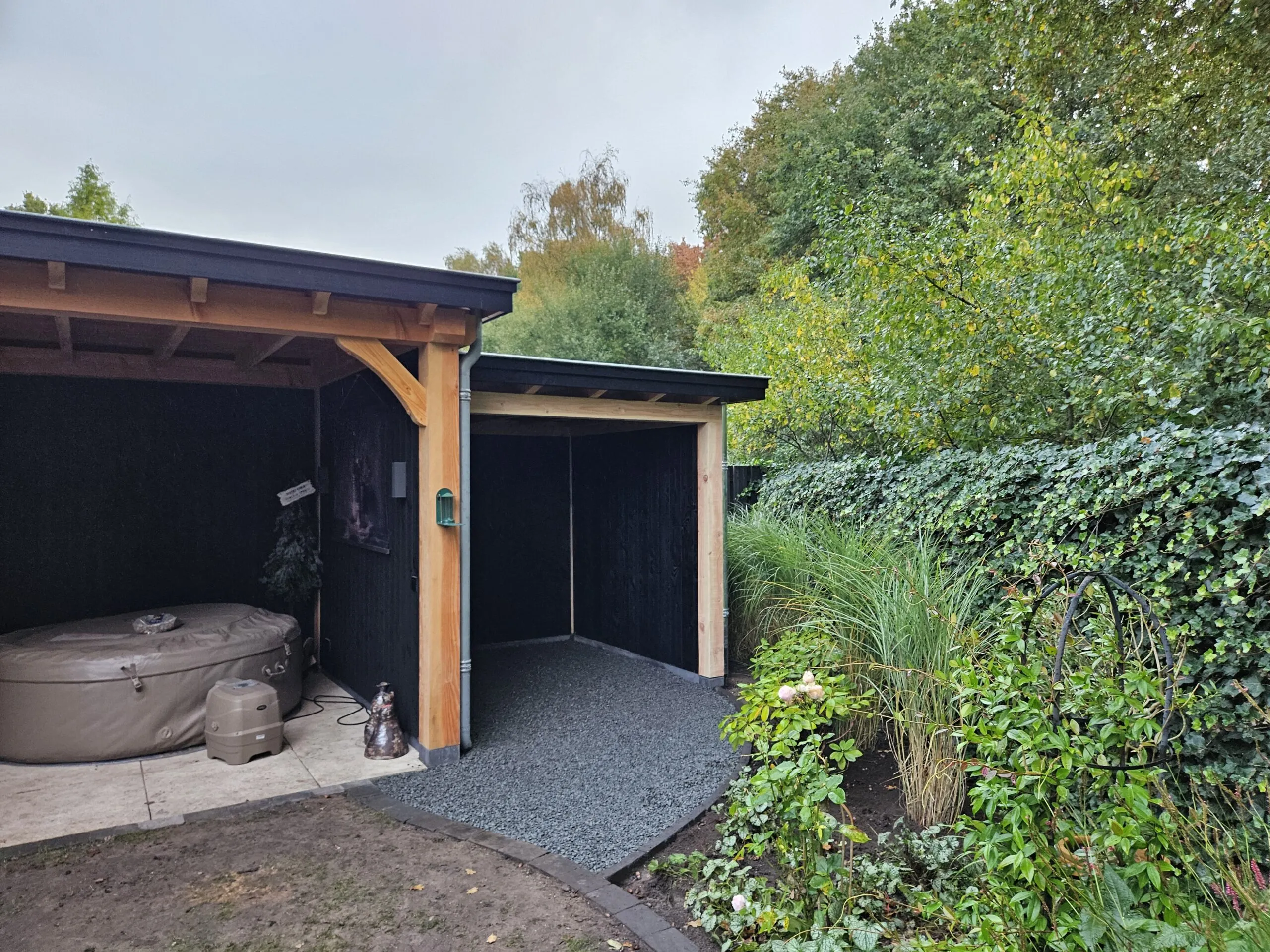 Houten overkapping met terras in een tuin in Heerde